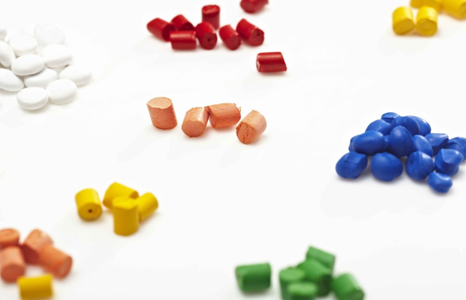 Engineering polymer granulate sorted by colour on a light surface